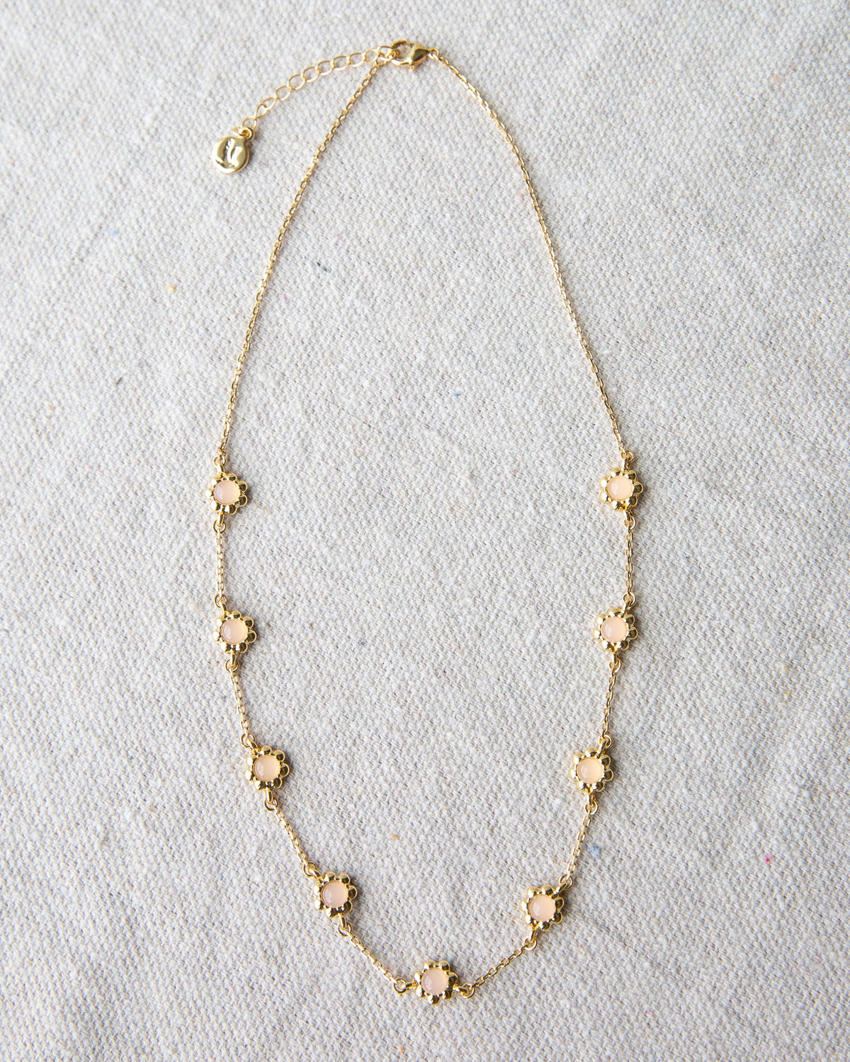 Mini flower necklace from Downeast featuring delicate floral pendant on a fine chain.