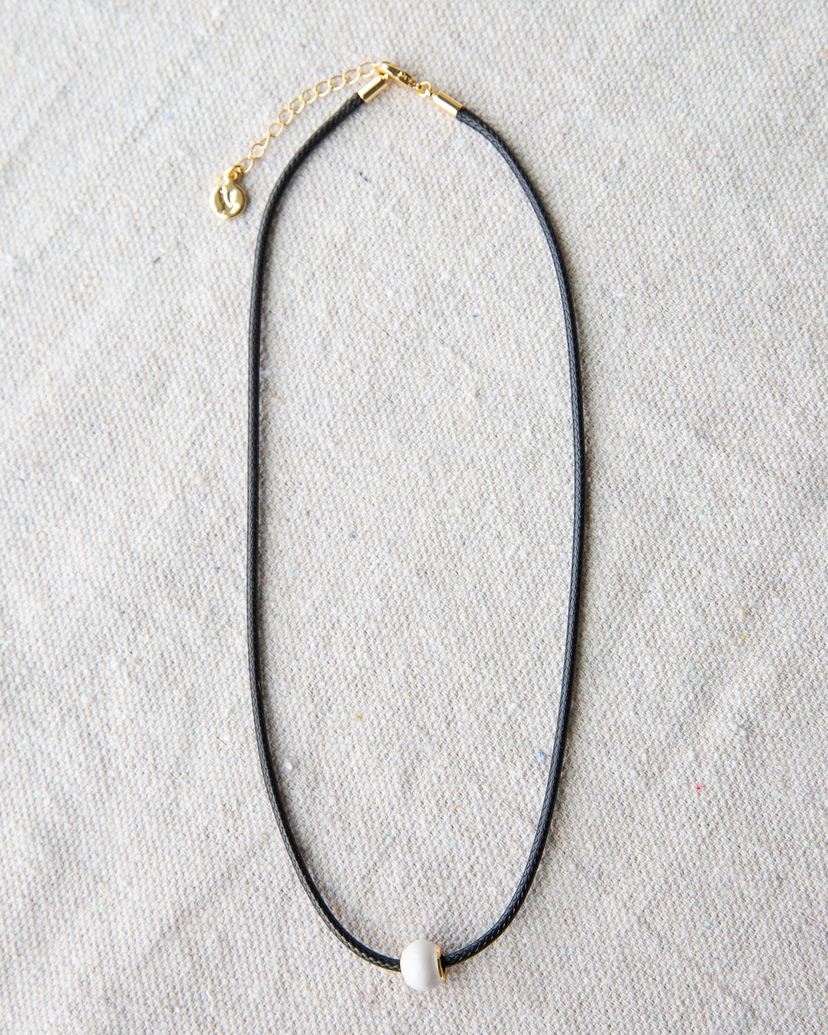 Downeast pearl and cord necklace with a delicate design, featuring white pearls and a black cord for a stylish accessory.