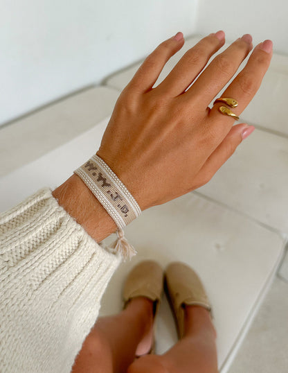 Beige WWJD embroidered bracelet wristband by Elevated Faith with faith-inspired design and stitching.