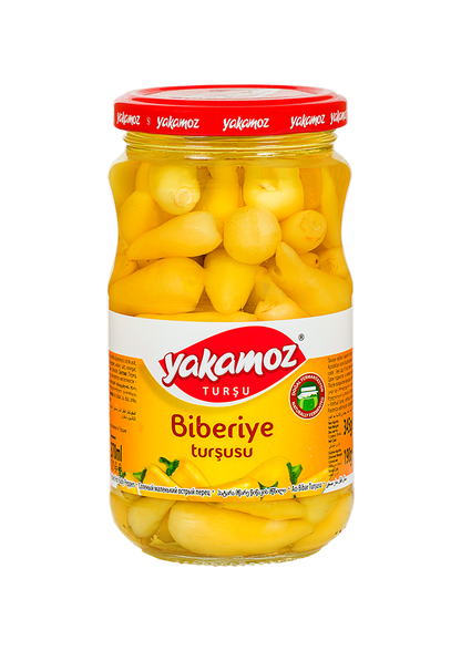 Glass jar of S101 Yakamoz Hot Baby Pepper Pickles with fresh peppers and herbs, ready for adding spicy flavor to dishes.