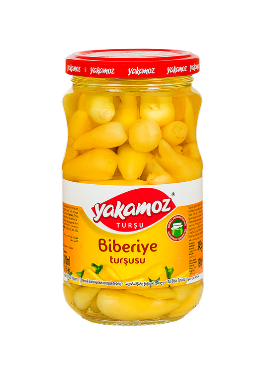 Glass jar of S101 Yakamoz Hot Baby Pepper Pickles with fresh peppers and herbs, ready for adding spicy flavor to dishes.