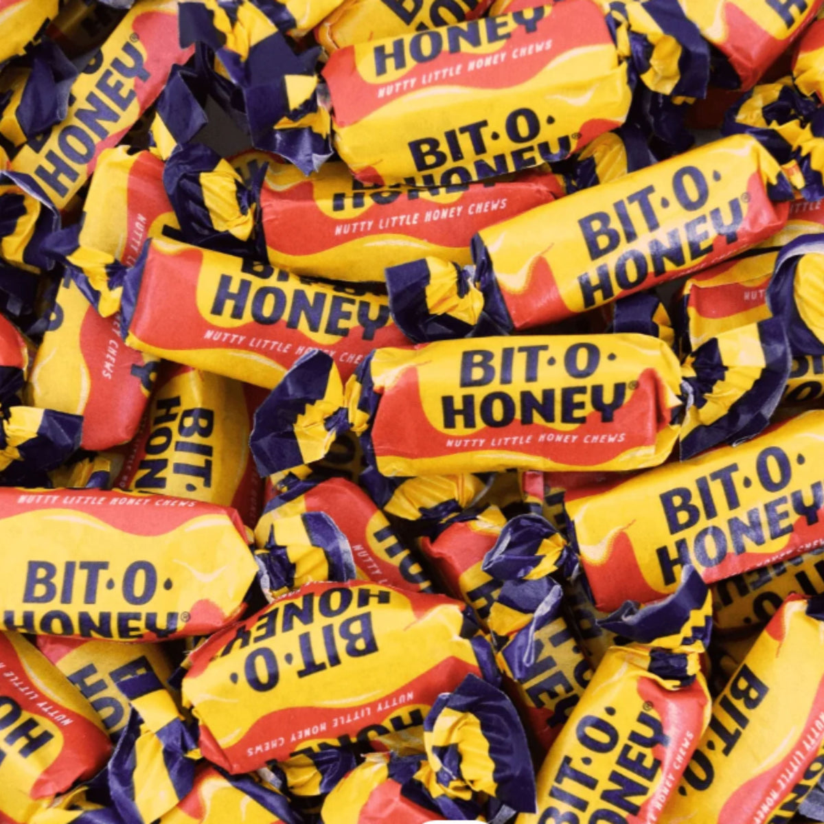 Assorted Bit-O-Honey taffy candies in a bulk value bag, showing individually wrapped honey-flavored chewy candies by Candy In Bulk.