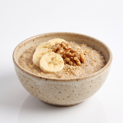 Bowl of banana nut oatmeal by ProtiDiet featuring creamy oats, banana slices, and nut topping, served in a white bowl.
