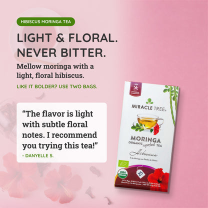 Organic Moringa and hibiscus herbal tea in a clear glass cup, featuring vibrant red hibiscus petals and green moringa leaves.