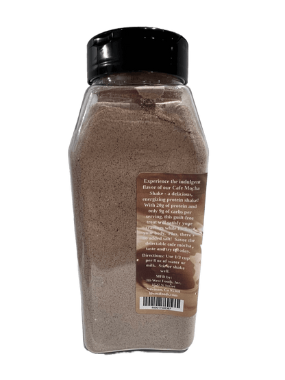 Hi-West Cafe Mocha Protein Shake in a glass with a creamy mocha appearance, topped with whipped cream and chocolate drizzle.