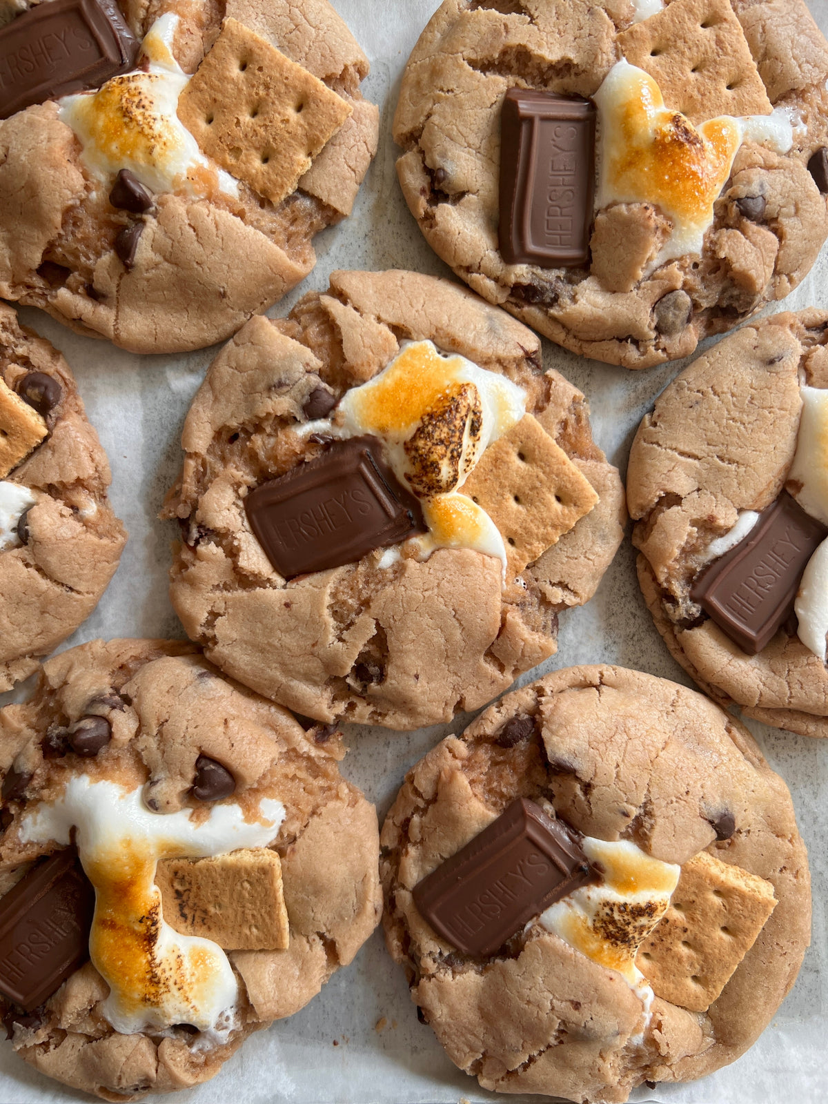 Let's Get Baked Artisan Desserts S'mores cookies with toasted marshmallow and chocolate chips on a plate.