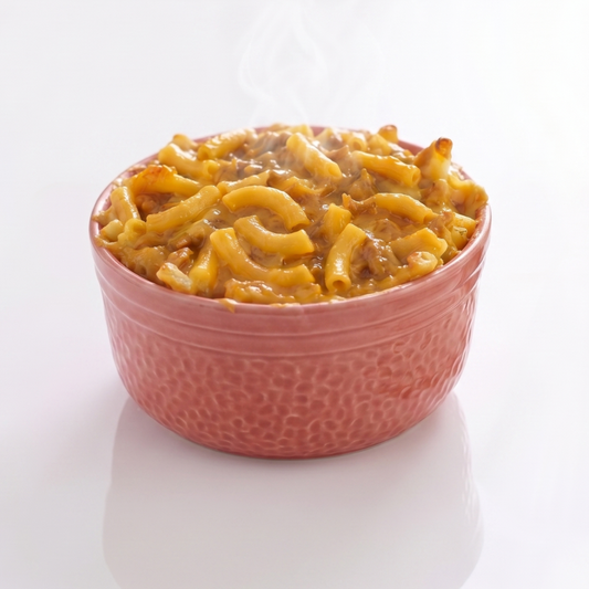 Creamy CheeseSteak Pasta bowl by AmBari Nutrition featuring pasta with cheese and sliced steak pieces.