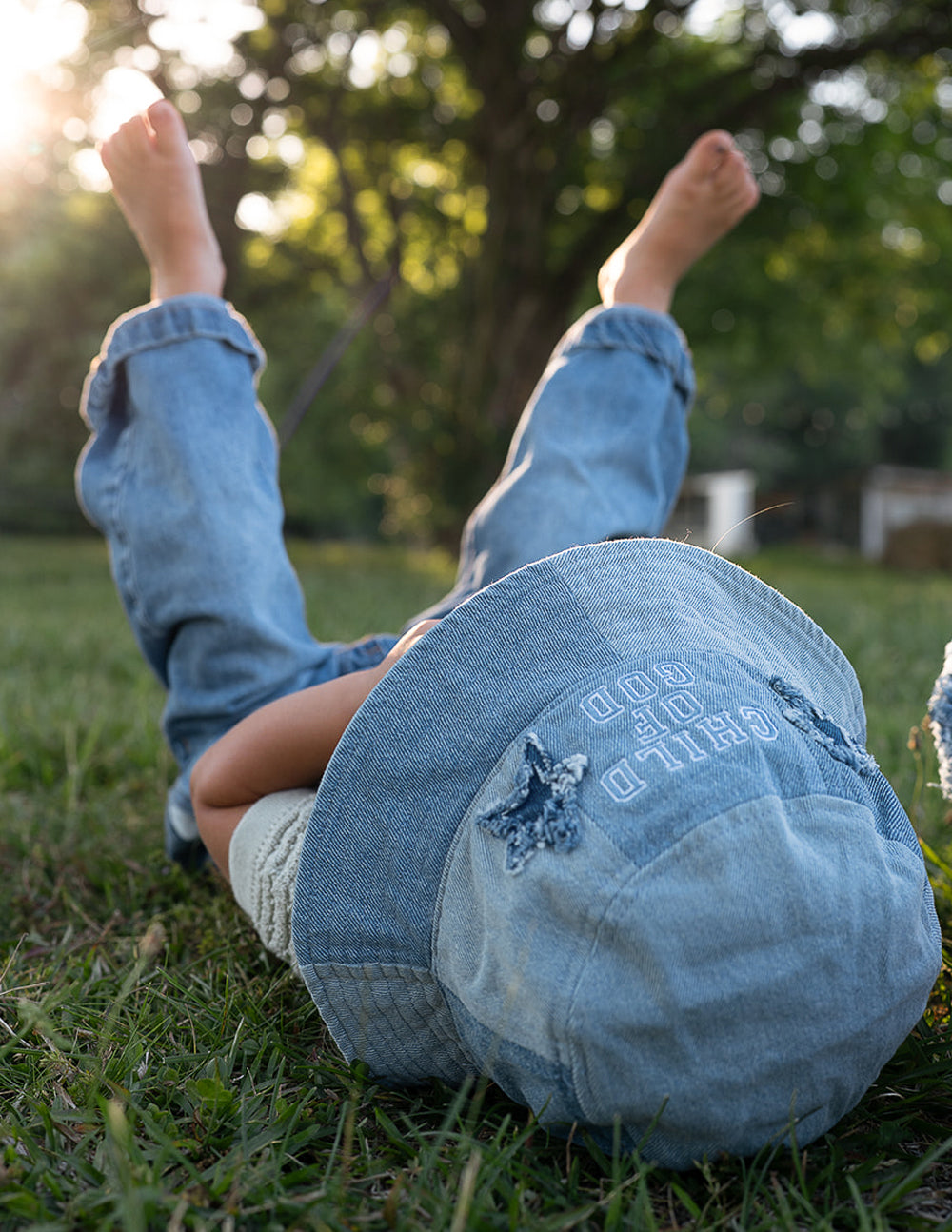 Children's denim bucket hat with "Child of God" embroidery by Elevated Faith, featuring a brim and casual kids' hat style.