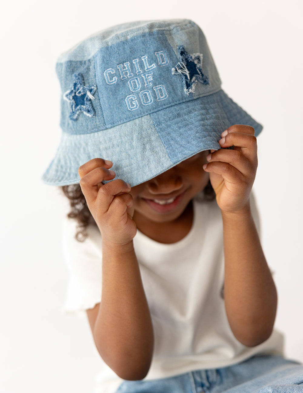 Child of God denim kids bucket hat by Elevated Faith, featuring a stylish and durable design for young children.