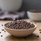 AmBari Nutrition Chocolate Mini Crisps in a bowl, showing small, crispy chocolate snacks with a glossy finish.
