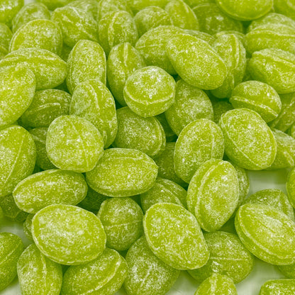 Green apple flavored Claeys hard candy drops from Candy In Bulk in a large bulk value bag, showcasing vibrant green candies.