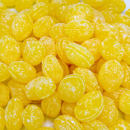 Claeys Lemon Sanded Drops hard candy in a bulk bag, showing bright yellow lemon-flavored candies with sugar coating.