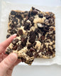 Cookies & Cream Blondie from Let's Get Baked Artisan Desserts showing a creamy, chocolatey blondie with cookie chunks.