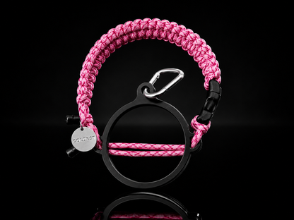 Coldest Paracord Handle accessory with pink and black design on a dark background, showcasing durable woven paracord material.