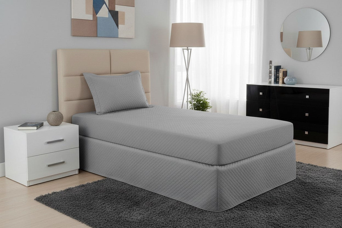 Maison Charlo gray waterproof quilted single mattress protector on a bed, showing soft fabric and fitted edges.