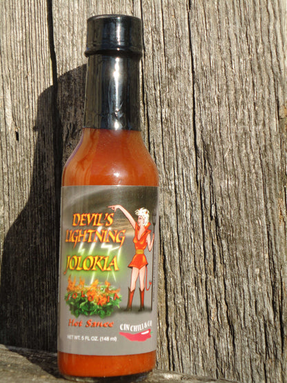 Cinderosa Ranch Devil's Lightning Bhut Jolokia ghost pepper hot sauce bottle on a wooden surface.