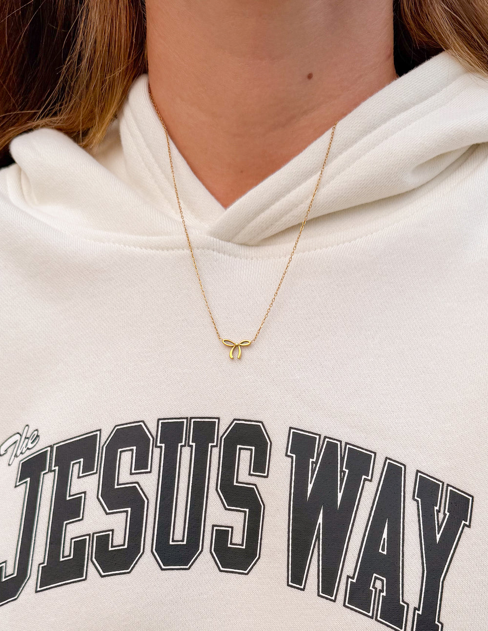 Delicate bow necklace by Elevated Faith featuring a small elegant charm on a fine chain.