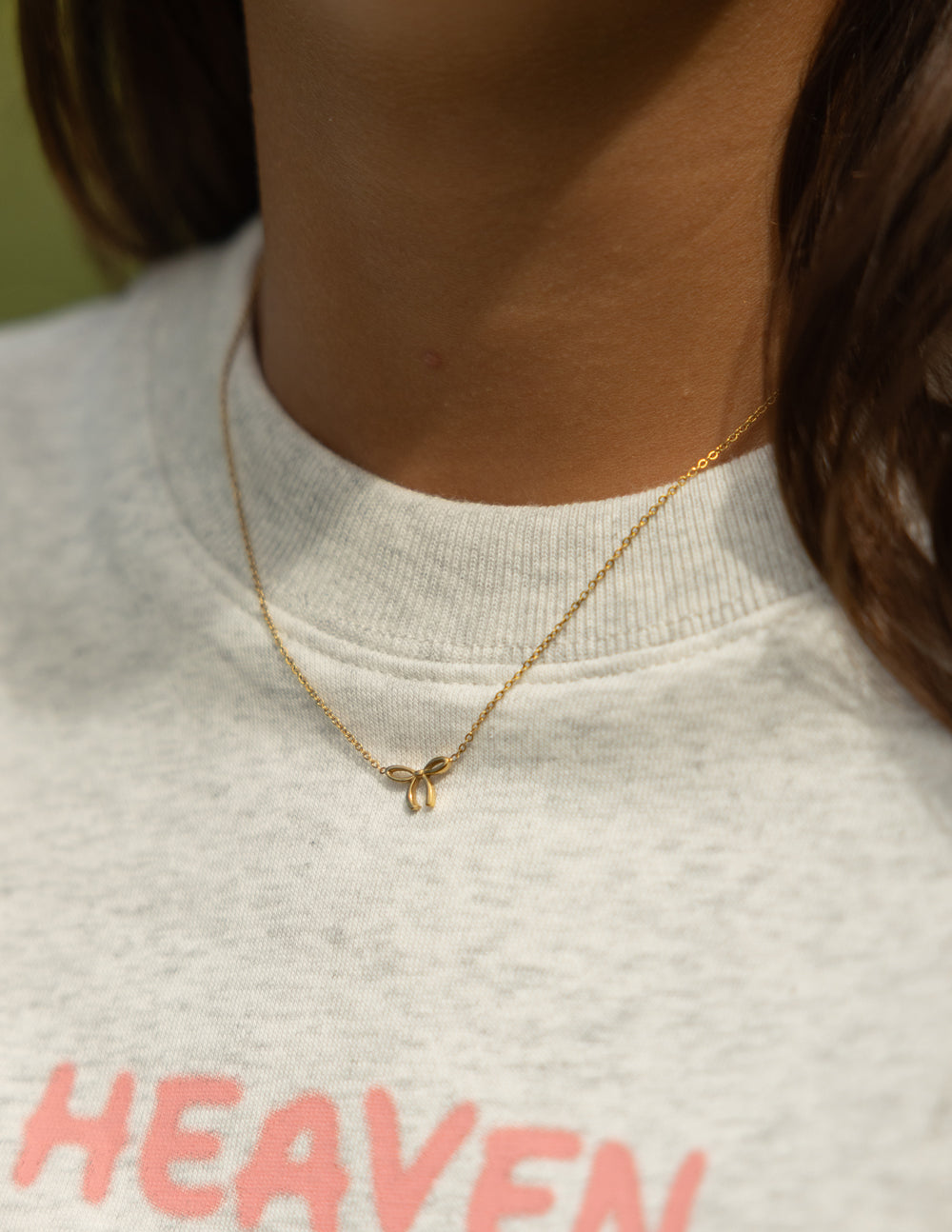Silver dainty bow necklace from Elevated Faith, featuring a delicate design on a fine chain.