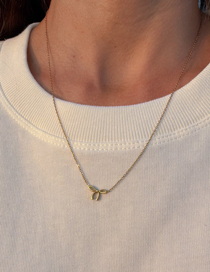 Silver dainty bow necklace by Elevated Faith featuring a delicate bow pendant on a fine chain.