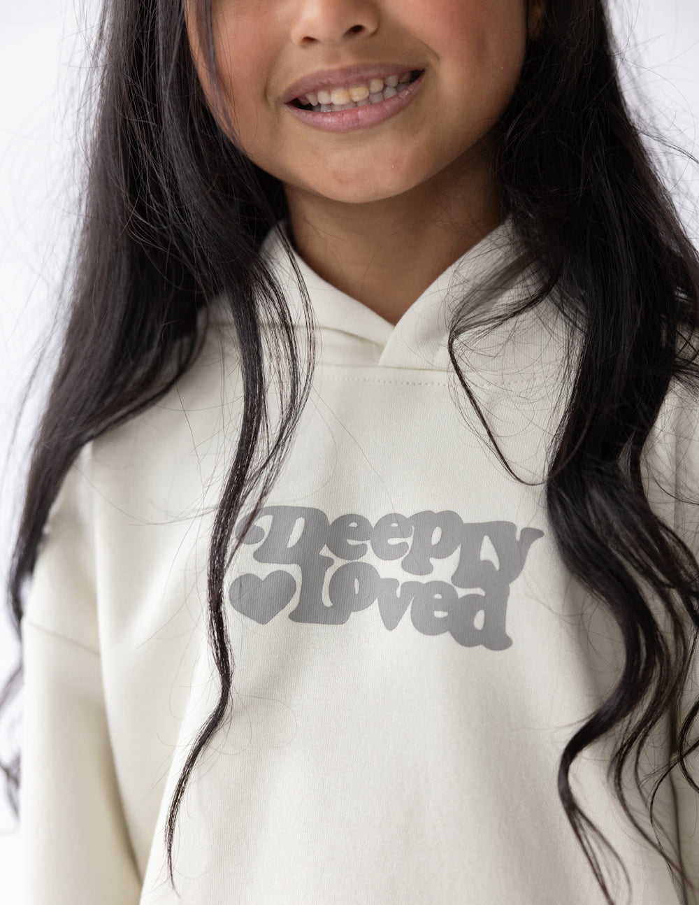 Bright pink kids hoodie from Elevated Faith with "Deeply Loved" text, featuring a cozy design for children.