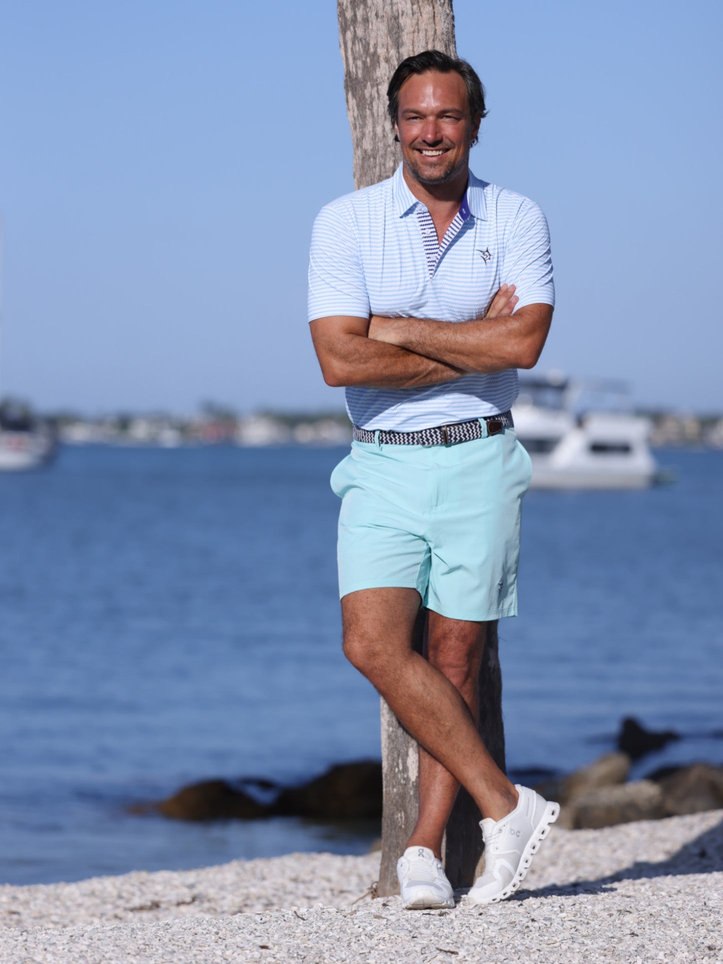 White Water Life Freeport Short Effortless Performance shorts in aqua color, displayed on a dock with a polo shirt.