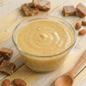 Delicious AmBari Nutrition English toffee protein pudding in a cup, showcasing rich caramel-colored toffee flavor and creamy texture.