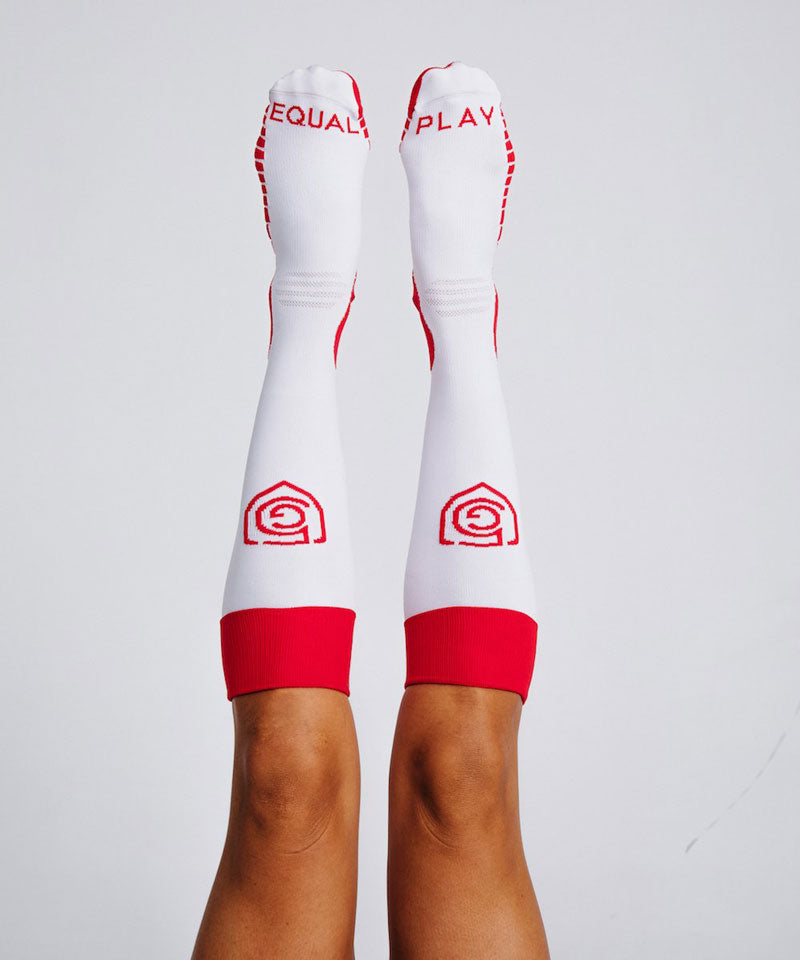 Equal Play women's over-the-calf soccer training socks by Goal Five in hot coral, designed for comfort and performance.