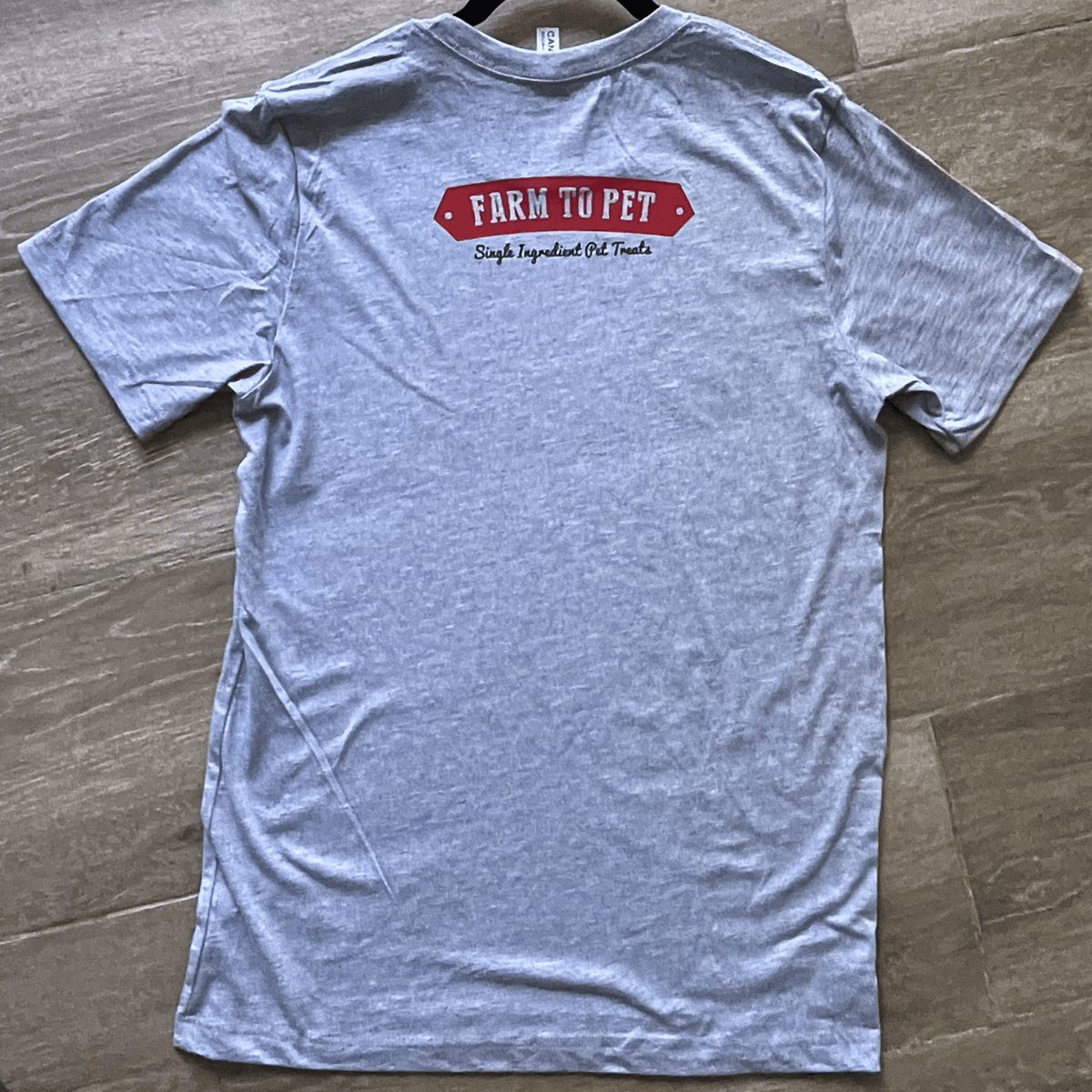 Gray Farm to Pet logo T-shirt showing the back side with a simple Farm to Pet design on the fabric.