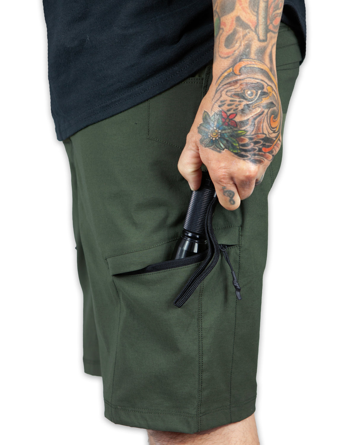 Dark army green Off The Grid Surplus field shorts with multiple pockets and rugged fabric, designed for outdoor wear.