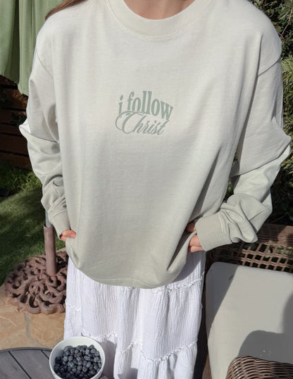 Black heavyweight T-shirt from Elevated Faith with "Follow Christ" printed design, long sleeve, casual fit.
