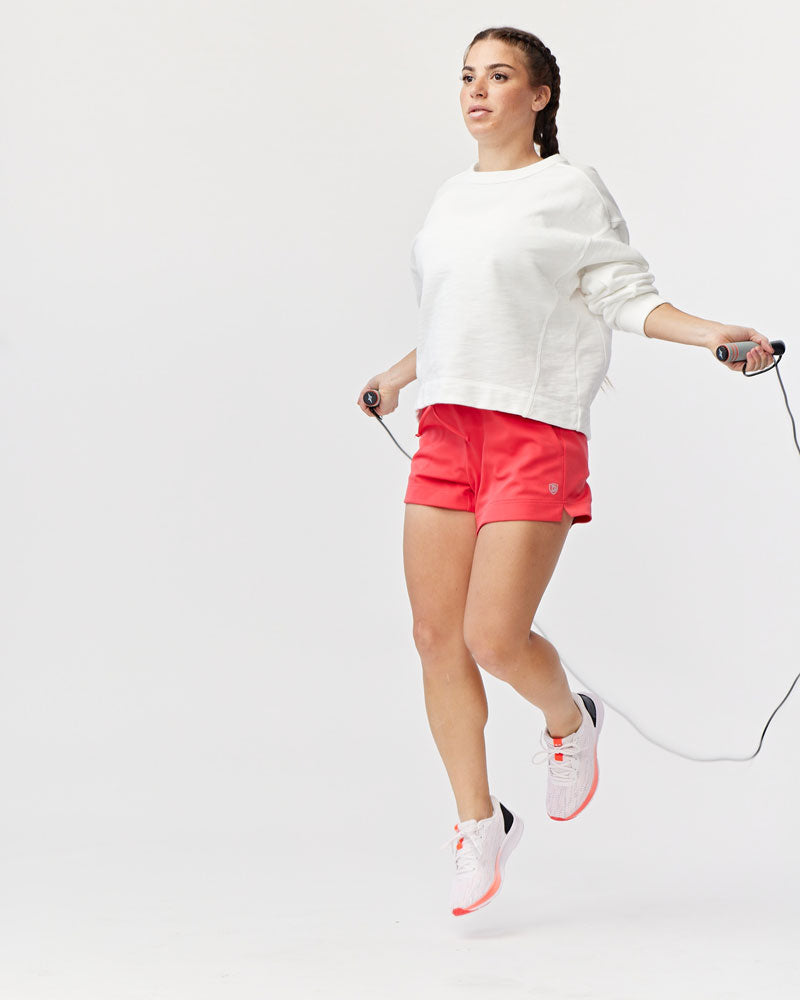 Goal Five G5 Advance 4.5-inch knit shorts in hot coral, showing the textured fabric and casual fit on a model.