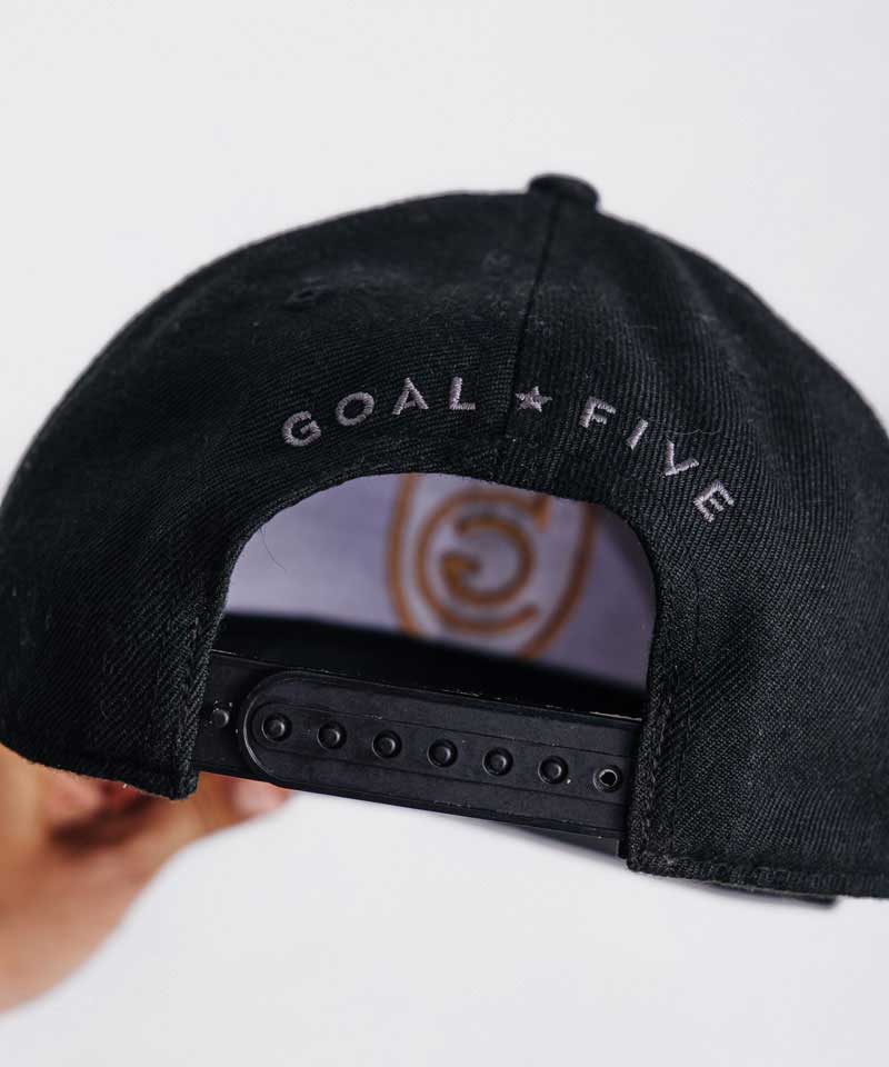 Goal Five G5 flat-billed snap back hat in lifestyle style, front view showing the adjustable strap and logo detail