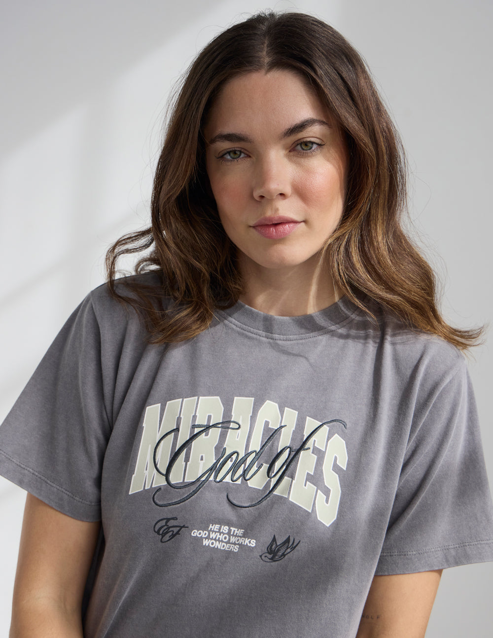 Black cropped women's T-shirt featuring a religious design with the words "God of Miracles" by Elevated Faith, casual and stylish.