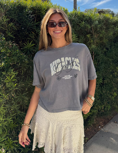 Elevated Faith God of Miracles cropped women's T-shirt with biblical design, white short sleeve tee for casual wear.