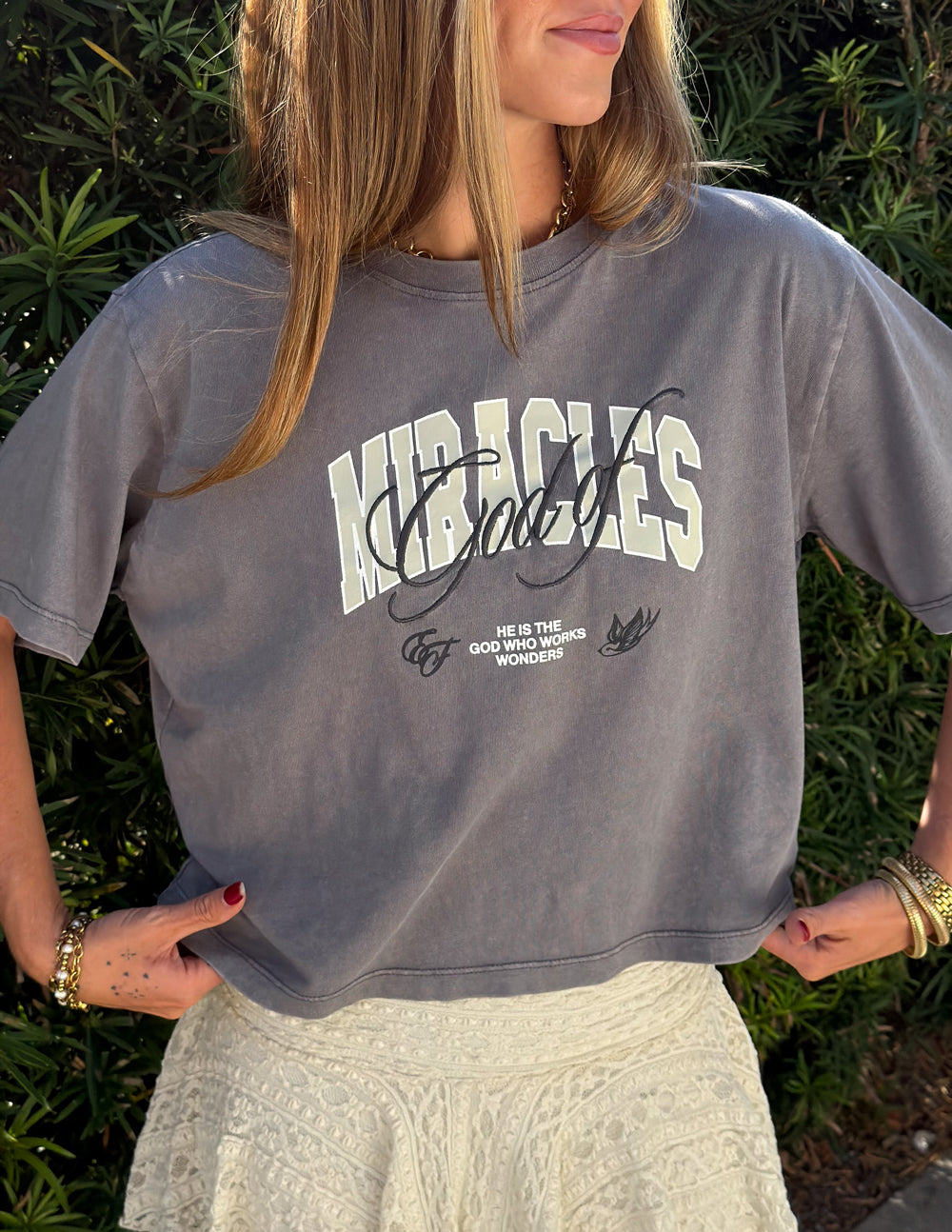 Black cropped women's T-shirt from Elevated Faith featuring the "God of Miracles" design in white print.