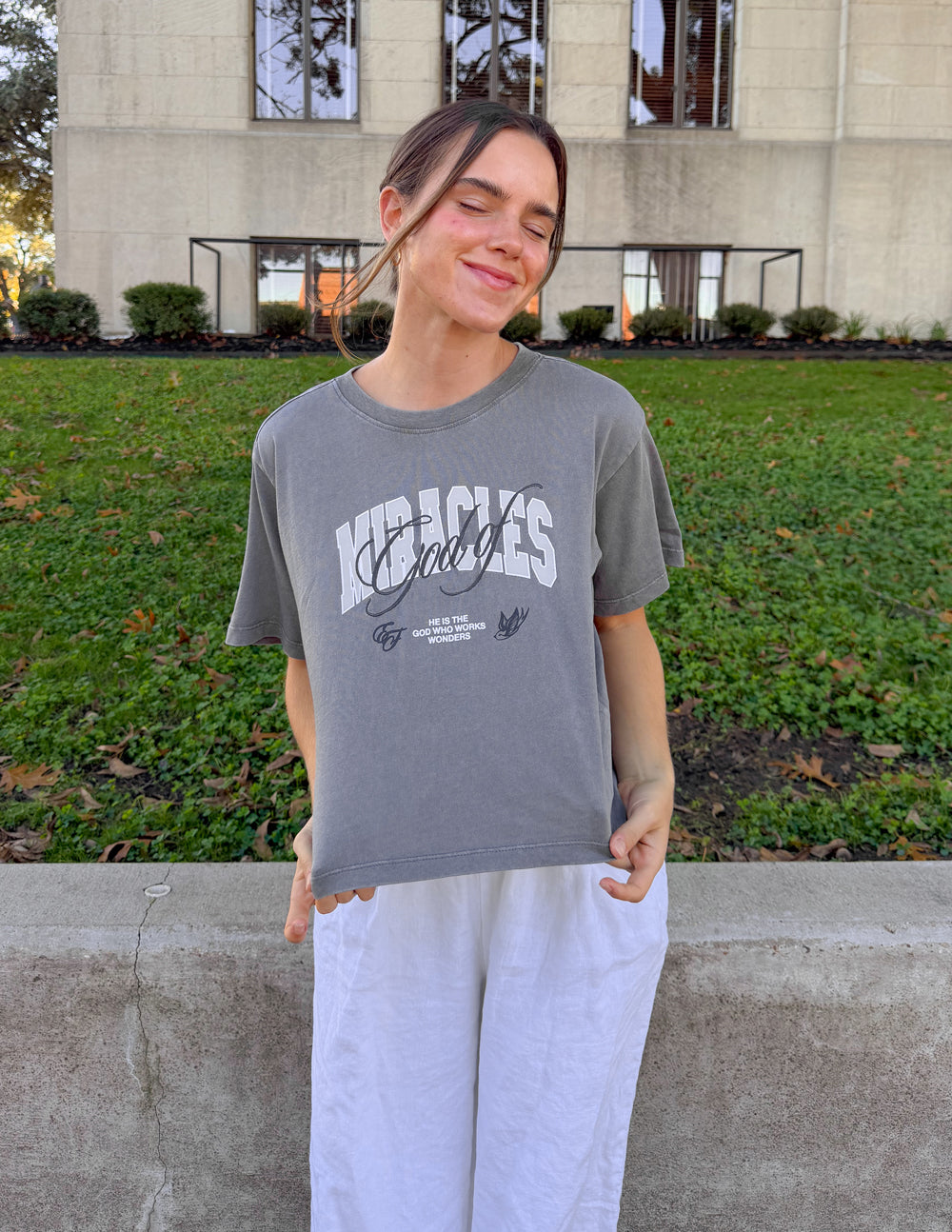 Black cropped women's T-shirt featuring the "God of Miracles" design by Elevated Faith, with a relaxed fit and bold printed text.