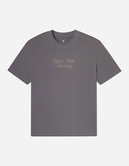 Unisex God's Still Working T-shirt by Elevated Faith featuring a faith-inspired graphic design on a comfortable cotton tee.