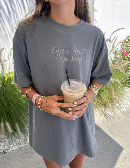 Elevated Faith God's Still Working unisex T-shirt featuring a bold design with faith-based message and comfortable fit.