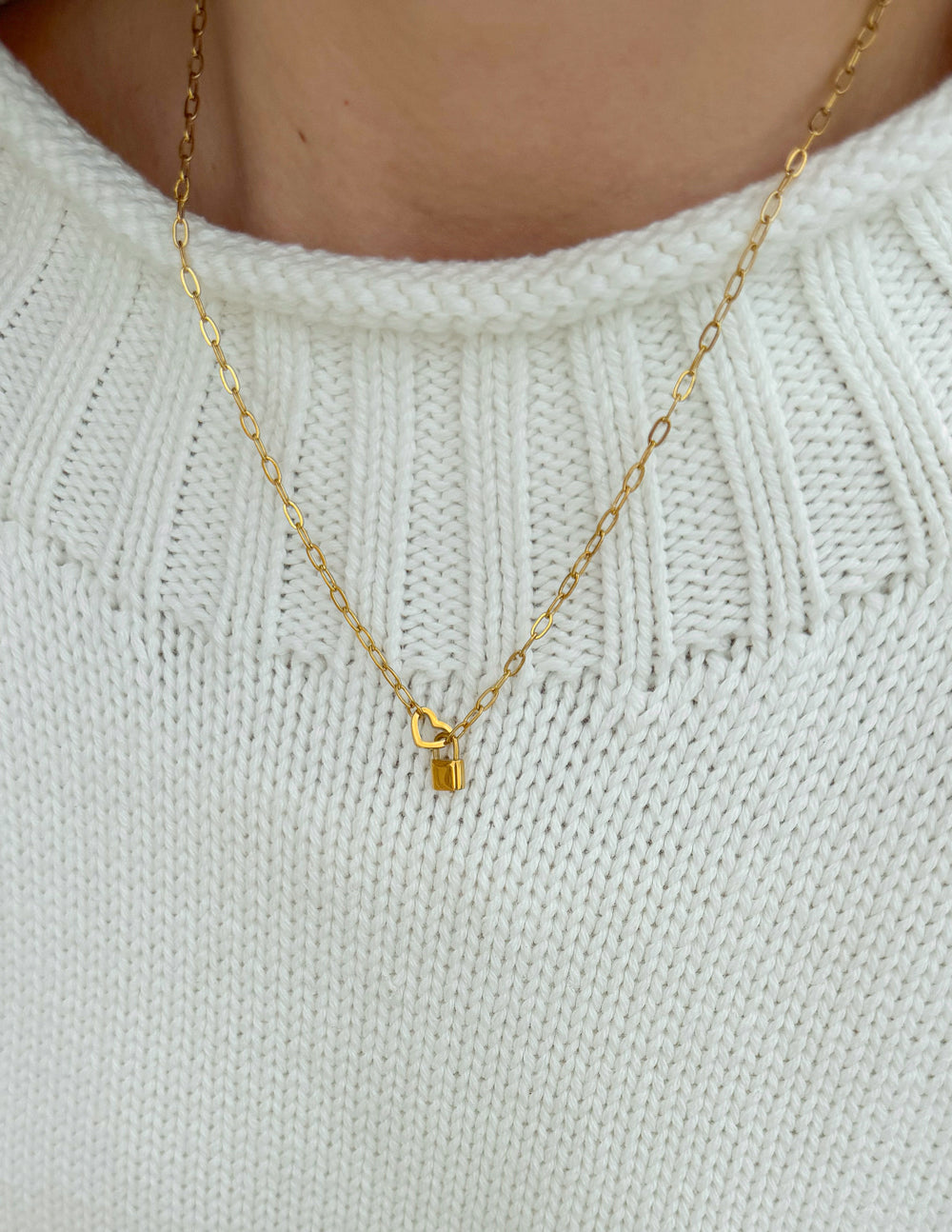 Elevated Faith heart lock paperclip chain necklace featuring a delicate heart-shaped lock pendant on a sleek chain.