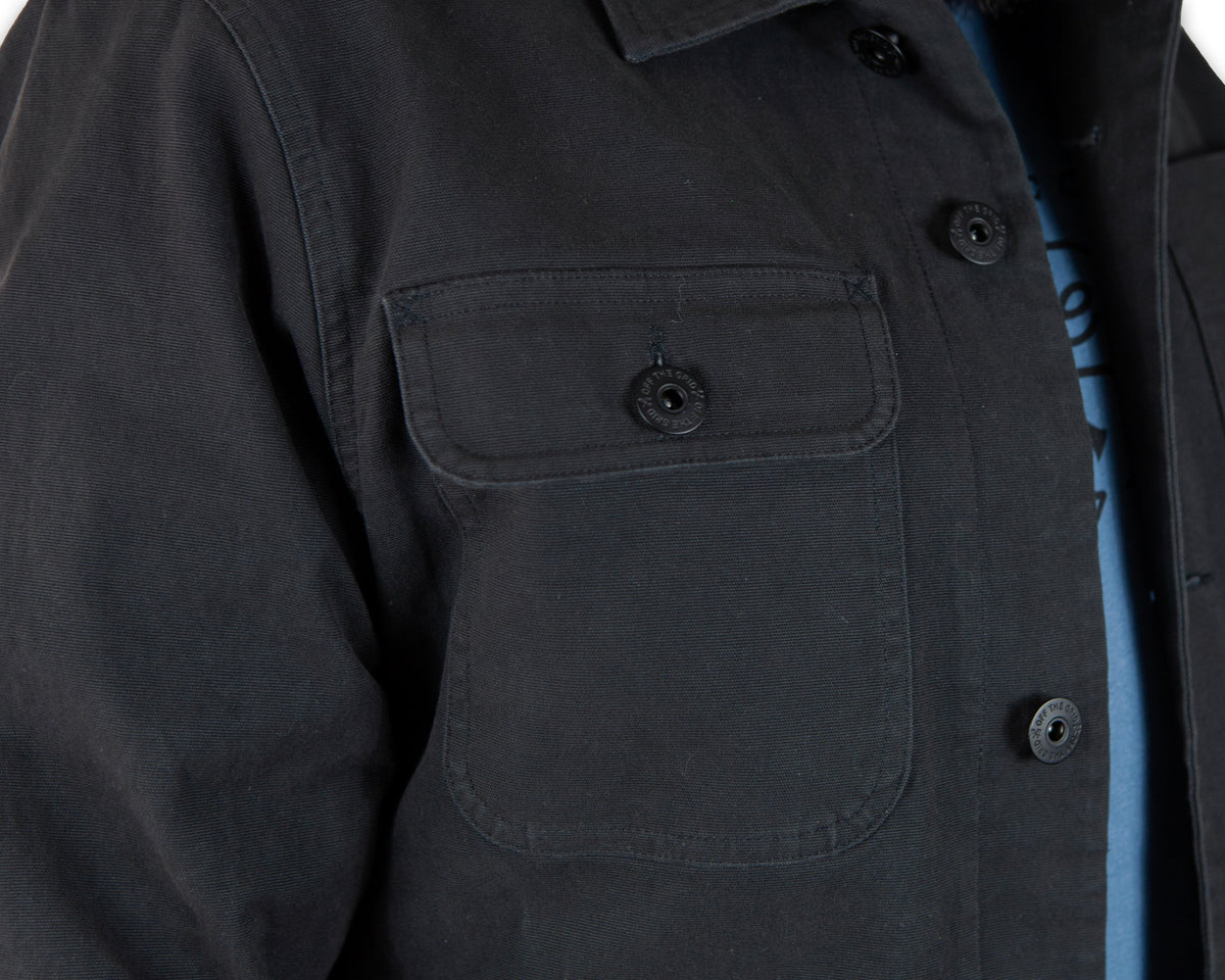 Black Heston Chore Coat by Off The Grid Surplus, a durable jacket with a classic workwear style and functional design.