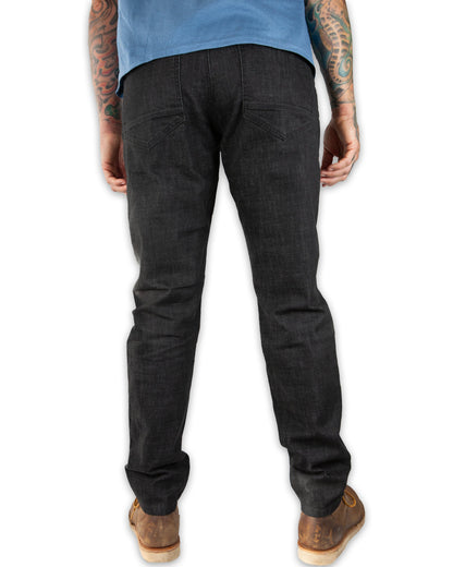 Black Off The Grid Surplus Hideout Denim Taper Fit Pants displayed on a hanger. Slim fit, tapered denim style.