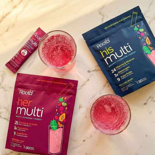 Couples' wellness pack featuring Root'd hydrating multivitamins for her and him, with bottles of daily multivitamin supplements.