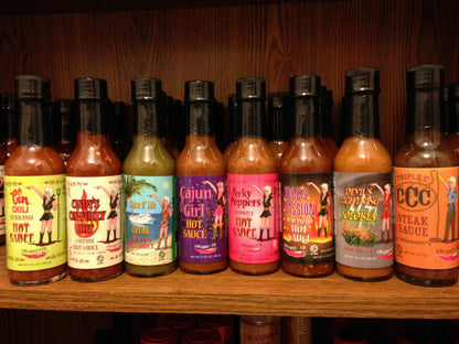 Cinderosa Ranch Bruce's Pick All 8 Hot Sauces combo set with various colorful bottles on a wooden table.