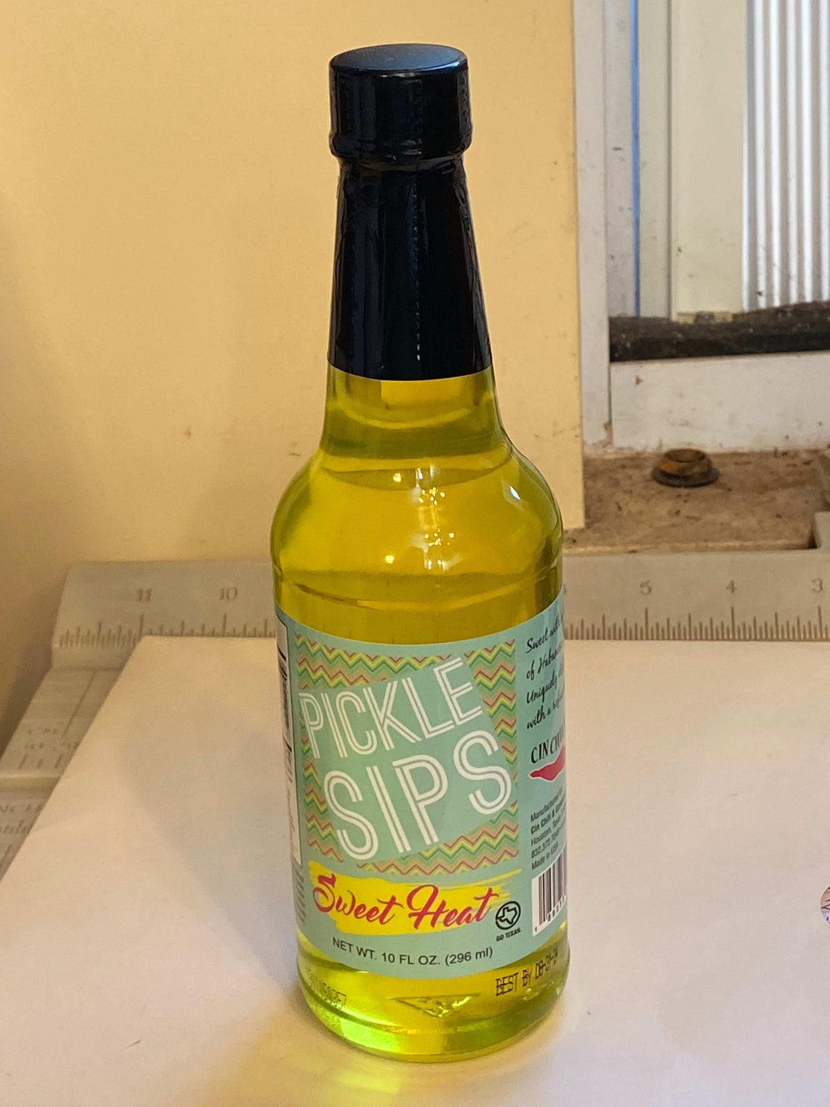 Cinderosa Ranch Pickle Sips Sweet Heat, 10 fl oz bottle of spicy and sweet pickle-flavored beverage with colorful packaging
