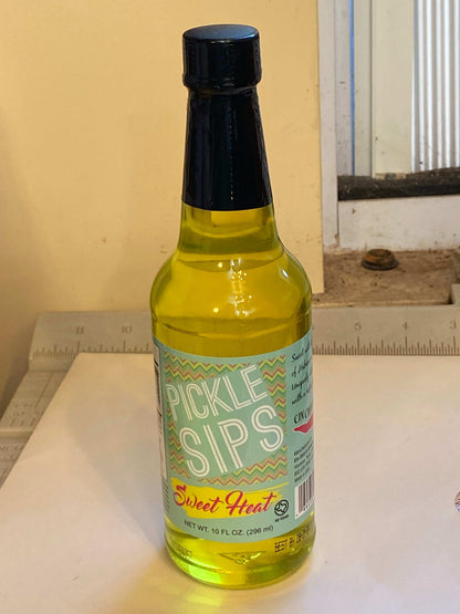 Cinderosa Ranch Pickle Sips Sweet Heat, 10 fl oz bottle of spicy and sweet pickle-flavored beverage with colorful packaging