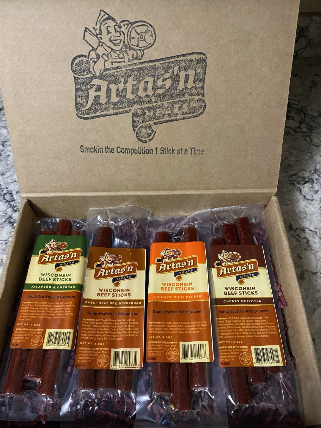 Artas'n Meats Spicy 4 Beef Stick Pak in gift box, featuring individually wrapped spicy beef jerky sticks arranged attractively.