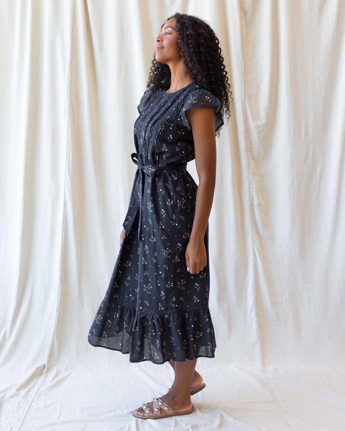Downeast Pretty Pintuck Dress displayed on a hanger, showcasing its elegant design and pintuck details.