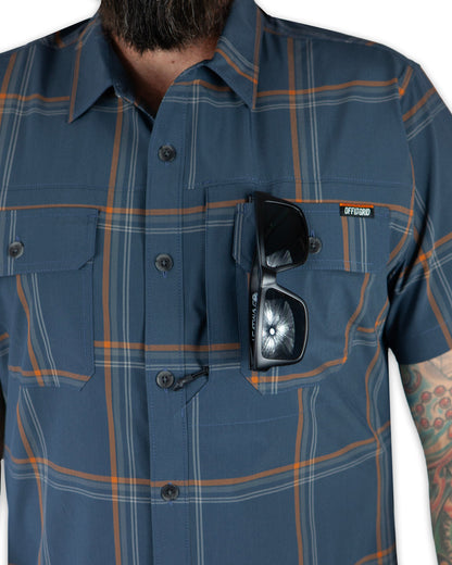 Dark gray blue short sleeve Jack Knife SS shirt by Off The Grid Surplus, displayed on a hanger against a plain background.