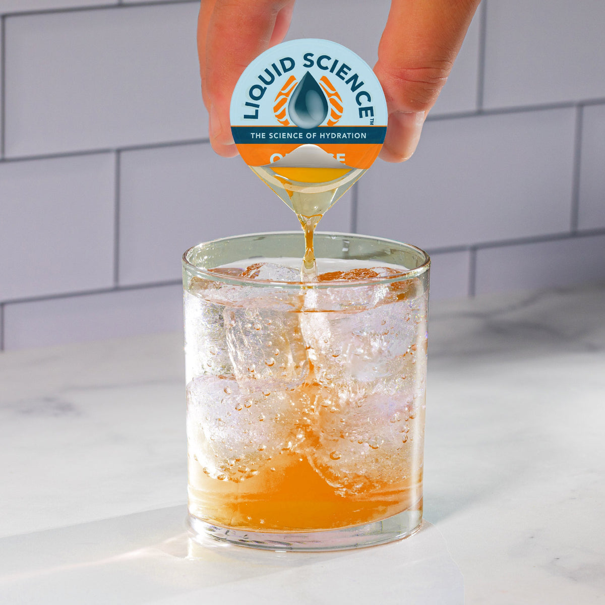 Liquid Science Orange Hydration Pods by Java House, close-up of orange-flavored electrolyte drink pods on a white background.