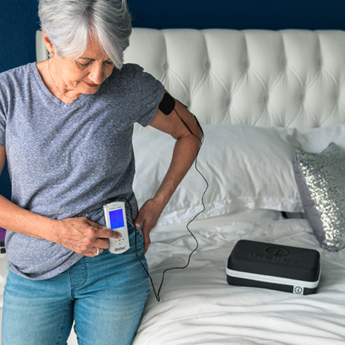 iReliev TENS unit for pain relief and recovery, shown in a lifestyle setting with a portable device and electrode pads.